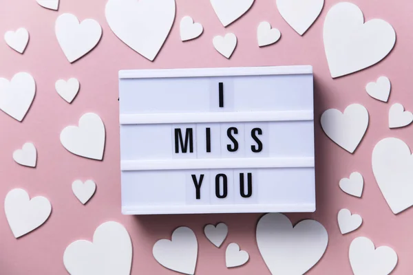 Eu sinto sua falta lightbox mensagem com corações brancos em um fundo rosa — Fotografia de Stock
