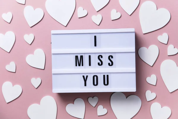 I miss you lightbox message with white hearts on a pink background