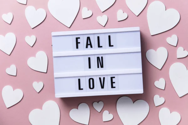 Apaixone-se lightbox mensagem com corações brancos em um fundo rosa — Fotografia de Stock