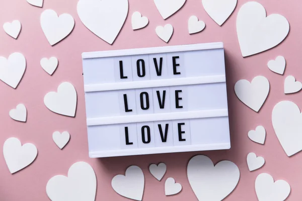 Amor lightbox mensagem com corações brancos em um fundo rosa — Fotografia de Stock