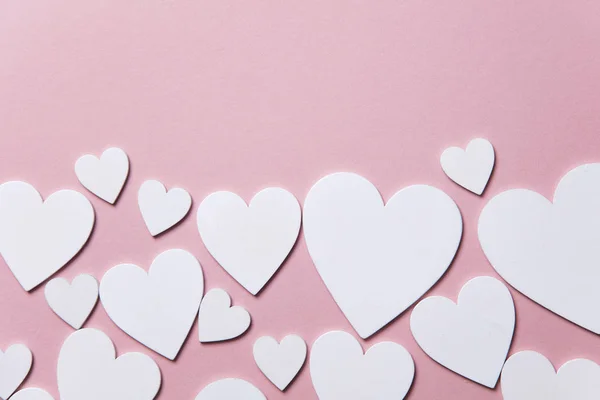 Corações brancos em um fundo rosa pastel . — Fotografia de Stock