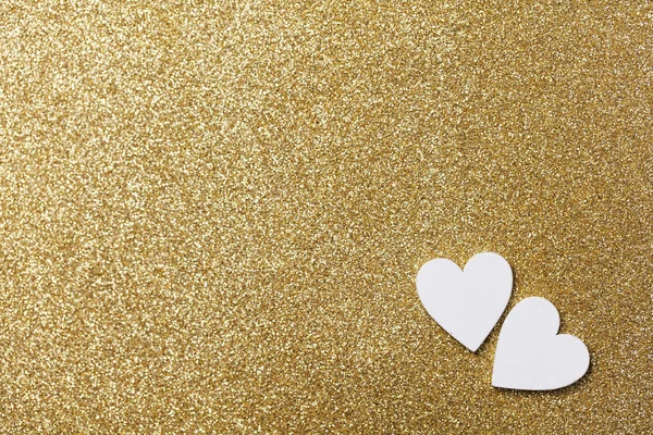 White heart shape on a golden glitter backgrond