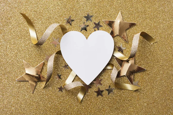 White heart shape on a golden glitter backgrond