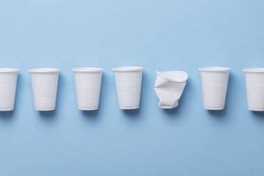 Tek Kişilik Kullanım beyaz plastik bardak mavi bir arka plan üzerinde