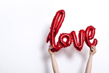 Kırmızı folyo aşk balon düz beyaz arka plan karşı düzenlenen