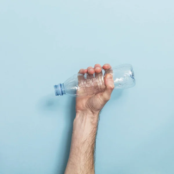 Handen Håller Tom Plastflaska Återvinning Mot Blå Bakgrund — Stockfoto