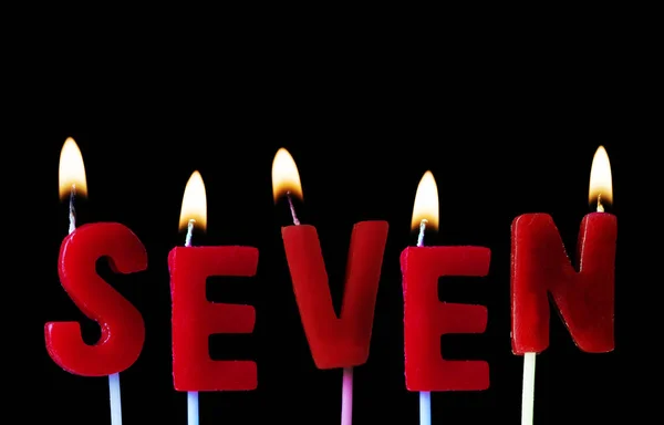 Sete Soletrado Velas Aniversário Vermelho Contra Fundo Preto — Fotografia de Stock