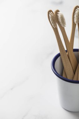 Ahşap bambu toothbrushs beyaz bir tencerede