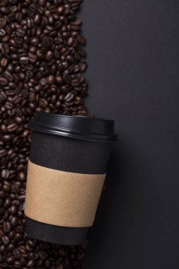 Siyah kahve fincanı kavrulmuş kahve çekirdekleri ile götürün