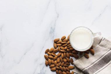 Tarafından organik badem çevrili bir bardak badem sütü