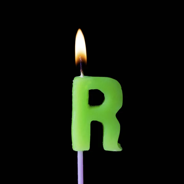 Carta R celebração aniversário vela contra um fundo preto — Fotografia de Stock