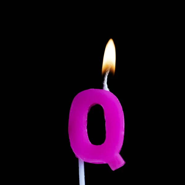 Lettera Q candela di compleanno celebrazione contro uno sfondo nero — Foto Stock