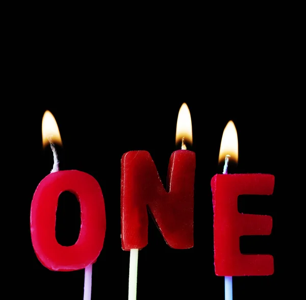 Um soletrado em velas de aniversário vermelhas contra um fundo preto — Fotografia de Stock