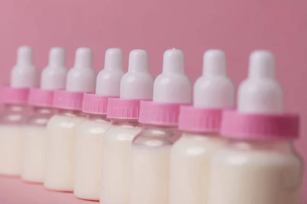 Teljes tej, egy rózsaszín háttér cumisüveg — Stock Fotó