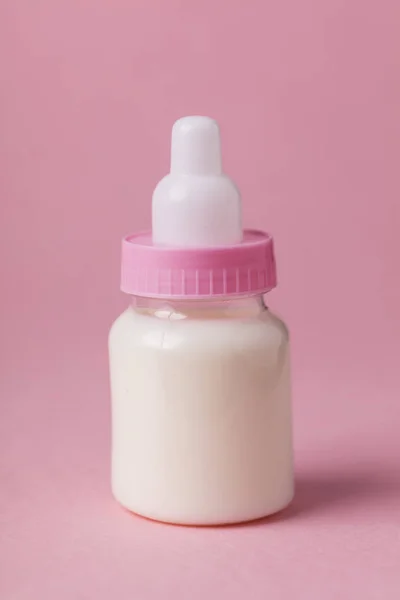 Teljes tej, egy rózsaszín háttér cumisüveg — Stock Fotó