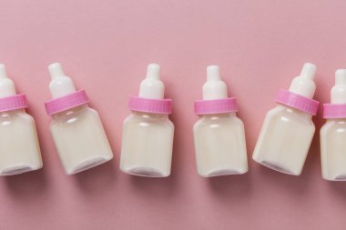 Biberon ile süt pastel pembe bir arka plan üzerinde