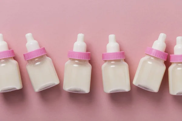 Cumisüveg tejjel, a pasztell rózsaszín háttér — Stock Fotó
