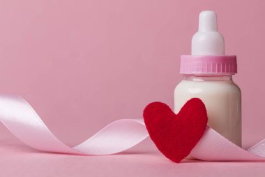 Pastel pembe bir arka plan üzerinde bebek şişe. Yeni Bebek varış