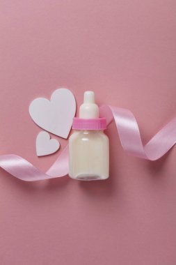 Pastel pembe bir arka plan üzerinde bebek şişe. Yeni Bebek varış
