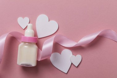 Pastel pembe bir arka plan üzerinde bebek şişe. Yeni Bebek varış