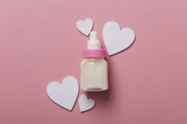 Pastel pembe bir arka plan üzerinde bebek şişe. Yeni Bebek varış