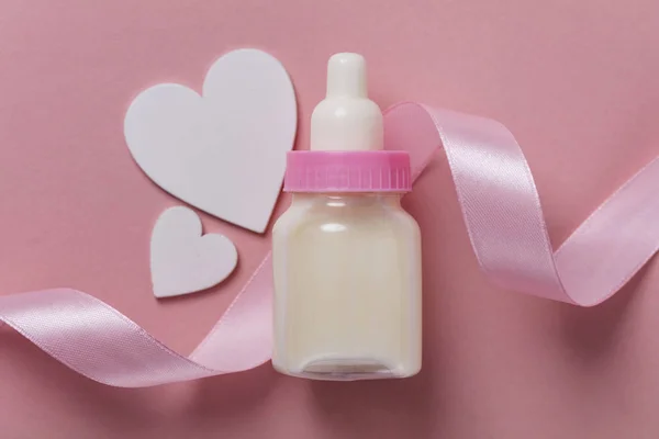 Babyfles op een pastel roze achtergrond. Nieuwkomer van de baby — Stockfoto