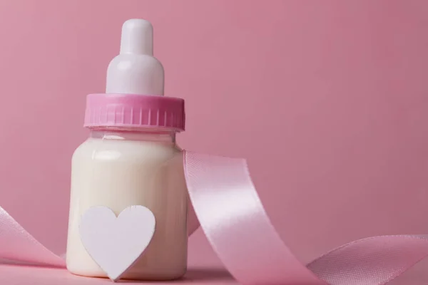 Babyfles op een pastel roze achtergrond. Nieuwkomer van de baby — Stockfoto