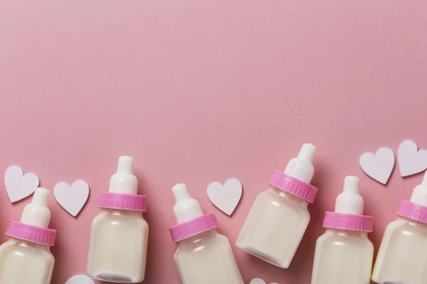Babyfles op een pastel roze achtergrond. Nieuwkomer van de baby — Stockfoto