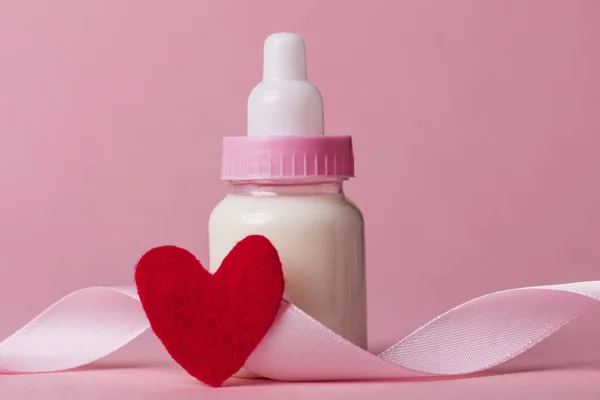 Babyfles op een pastel roze achtergrond. Nieuwkomer van de baby — Stockfoto