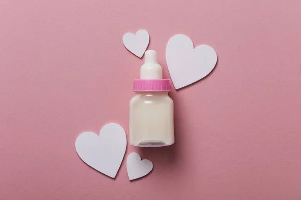 Babyfles op een pastel roze achtergrond. Nieuwkomer van de baby — Stockfoto