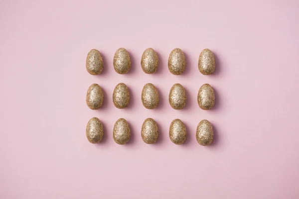 Gold glitzernde Ostereier auf pastellrosa Hintergrund. Frohe Ostern — Stockfoto