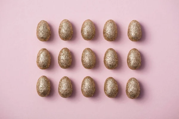 Gold glitzernde Ostereier auf pastellrosa Hintergrund. Frohe Ostern — Stockfoto