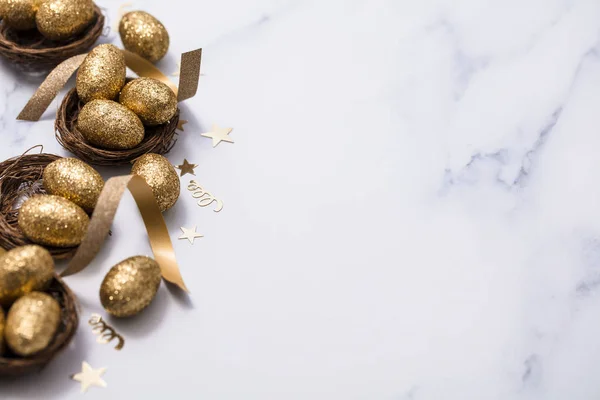 Œufs de paillettes dorées dans un nid. Fond de Pâques. Concept de financement — Photo