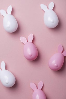 Paskalya yumurtaları pastel pembe bir arka plan üzerinde tavşan kulaklı