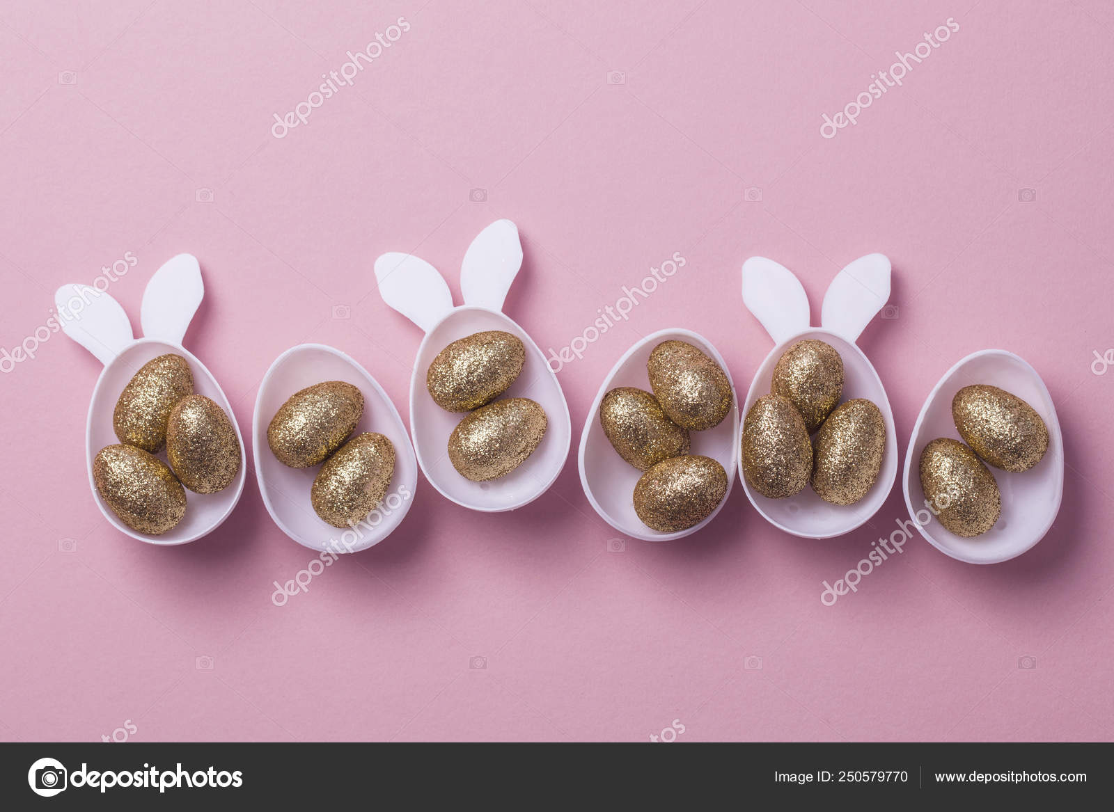 Gold glitter eggs in a white easter bunny egg shape with ears Stock