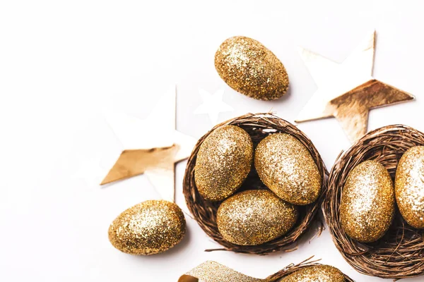 Œufs de paillettes dorées dans un nid. Fond de Pâques. Concept de financement — Photo