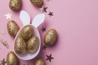 Altın yumurta kulakları ile beyaz bir Paskalya bunny yumurta şeklinde glitter