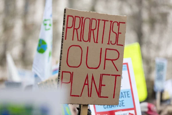 Pessoas com bandeiras protestam como parte de uma marcha de mudança climática — Fotografia de Stock