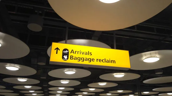 Chegadas e recuperação de bagagem assinar em um aeroporto internacional — Fotografia de Stock