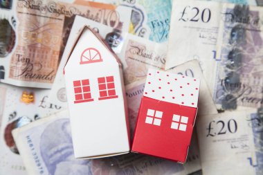 Konut maliyeti. Ingiliz para notları ile kağıt oyuncak ev