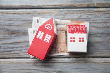 Konut maliyeti. Ingiliz para notları ile kağıt oyuncak ev