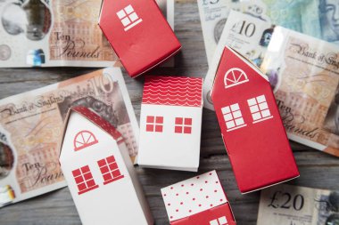 Konut maliyeti. Ingiliz para notları ile kağıt oyuncak ev