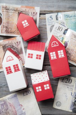 Konut maliyeti. Ingiliz para notları ile kağıt oyuncak ev