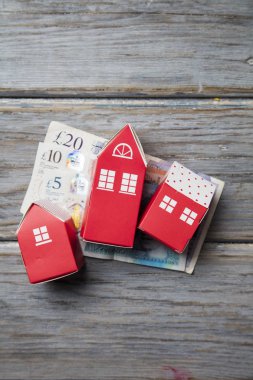 Konut maliyeti. Ingiliz para notları ile kağıt oyuncak ev