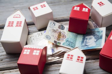 Konut maliyeti. Ingiliz para notları ile kağıt oyuncak ev