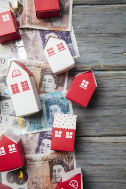 Konut maliyeti. Ingiliz para notları ile kağıt oyuncak ev