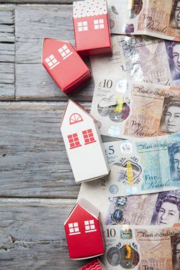 Konut maliyeti. Ingiliz para notları ile kağıt oyuncak ev