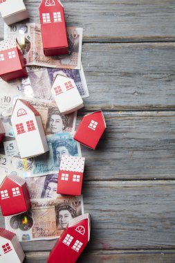 Konut maliyeti. Ingiliz para notları ile kağıt oyuncak ev