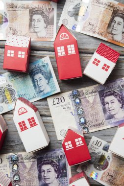 Konut maliyeti. Ingiliz para notları ile kağıt oyuncak ev