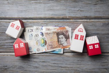 Konut maliyeti. Ingiliz para notları ile kağıt oyuncak ev